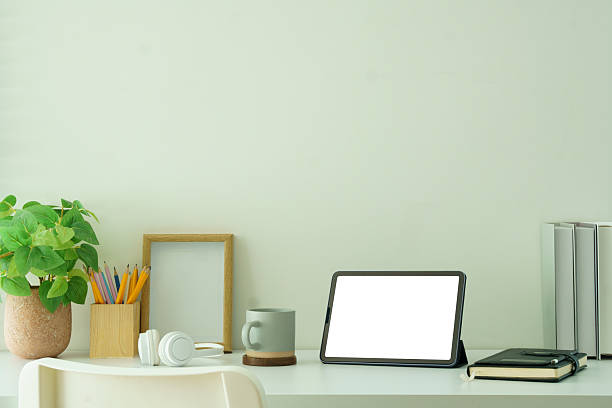 istock Creative workspace with blank tablet screen, framed photo and potted plant, ideal for showcasing productivity, or website mockups. 2221327387