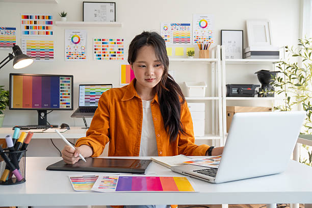 Female designer creating digital designs in a bright studio.Female designer creating digital designs in a bright studio.