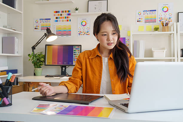 istock Young female designer creating digital designs in a bright studio. 2221327676