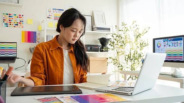 istock Young female designer creating digital designs in a bright studio. 2221327692