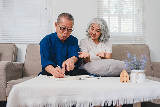istock Elderly Couple Sitting on Sofa, Discussing and Writing in Notebook With Cozy and Relaxed Atmosphere. 2221333579