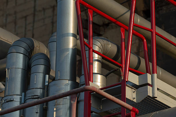 A collection of pipes is intricately connected to one another, held in place by a sturdy red railing for stability and support