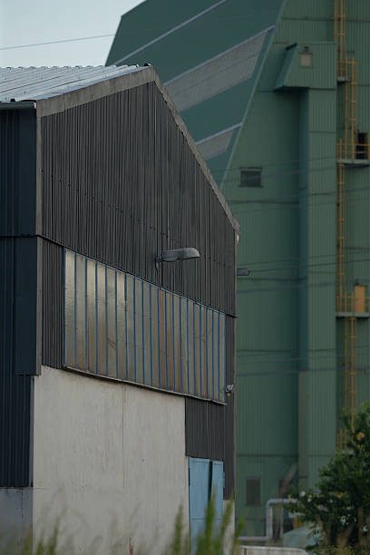 istock A large building with a green roof stands behind a smaller structure 2221338690