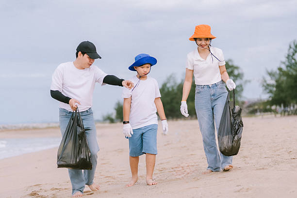 istock Family participates in beach cleanup activity while promoting environmental awareness on a cloudy day 2221340393