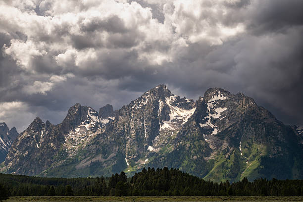 Teton Range Catch Bright Light As A Dark Storm Moves In over the peaks