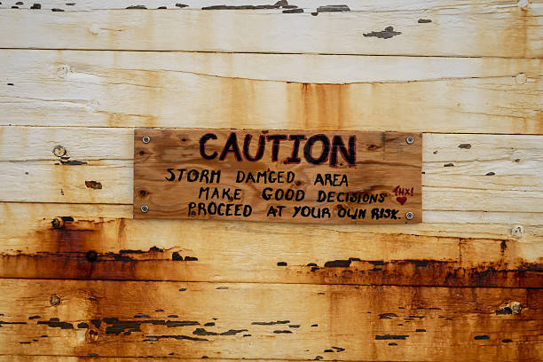 istock Caution Sign on Wooden Wall Indicates Prior Storm Damage 2221352920
