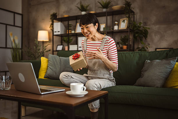 istock one mature woman open box presents and read card while on video call 2221353042