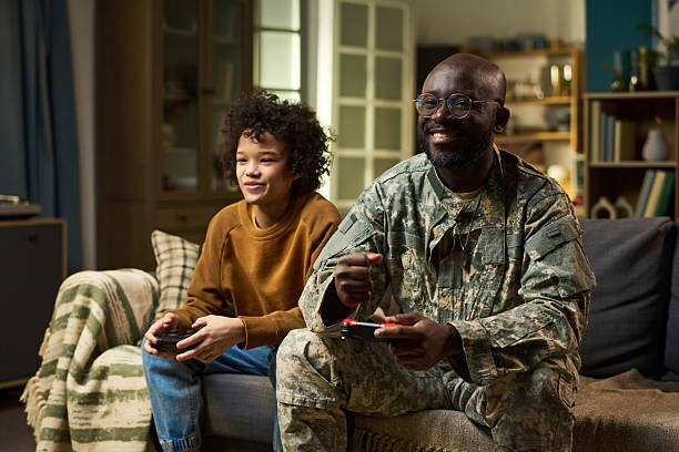 istock Middle Aged Black Man in Military Uniform Playing Video Game with Child 2221355372