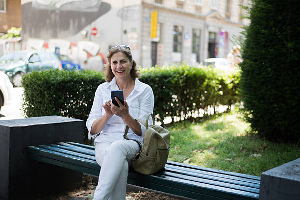 istock Senior woman using smart phone in the park 2221366492
