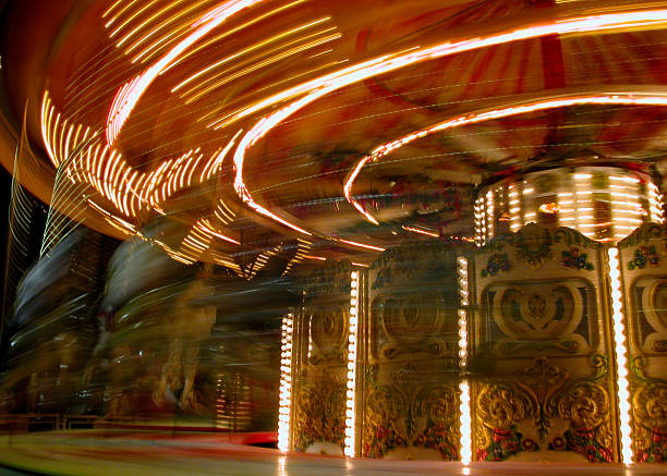 Bright streaks of light of a spinning carousel in motion, capturing the energy and excitement of a night at the fairground
