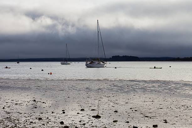 istock A sailboat sits on the water under a cloudy sky. 2221373650