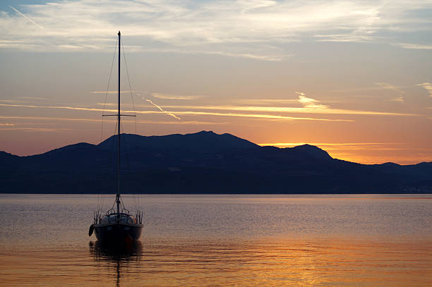 Calm sea with a sailboat in the early evening