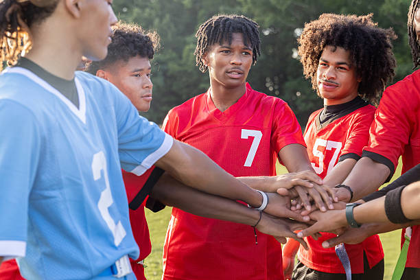 istock High school flag football team put their hands in huddle on sidelines during a game with teammates 2221392676