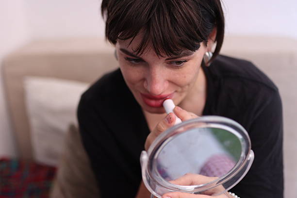 Beautiful woman is applying red lipstick