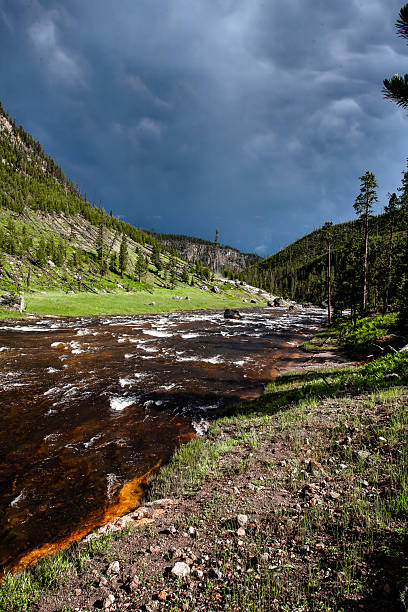 istock Yellowstone National Park River Scene with Storm Clouds - Vertical Format 2221404022