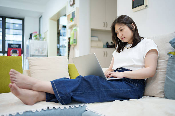 istock Asian woman sitting on the sofa and working from home 2221406854