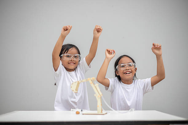 Mid adult female educator holding working lung model and talking with school children about how it simulates human breathing.