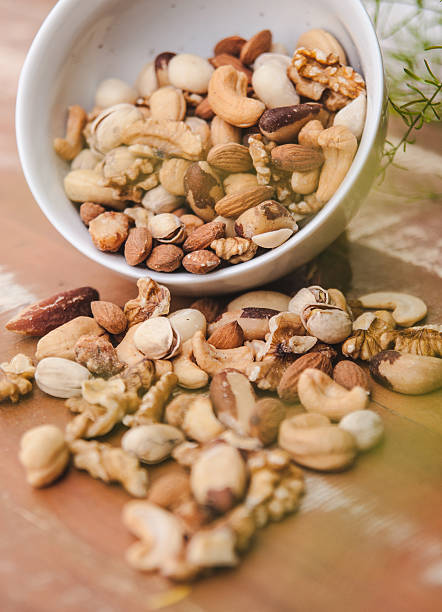 istock Assorted Nuts on Wooden Table with Green Accent – Healthy Snack 2221411164