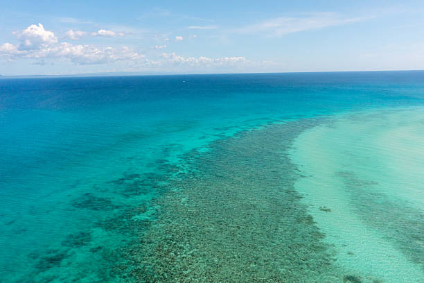 Tropical seascape with sea surface with corals and turquoise clear waters. Blue sky and clouds. Bantayan, Cebu, Philippines.