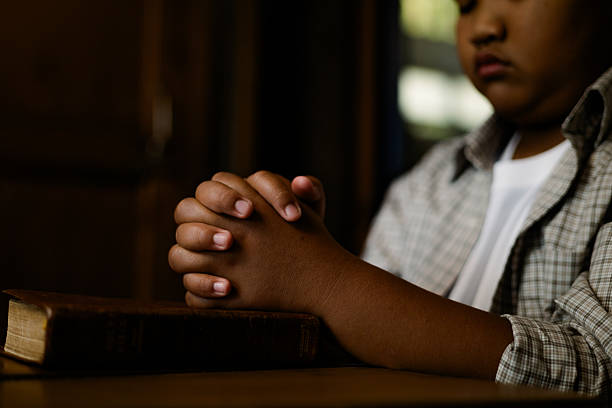 Close up of hands with Holy Bible in Catholic church