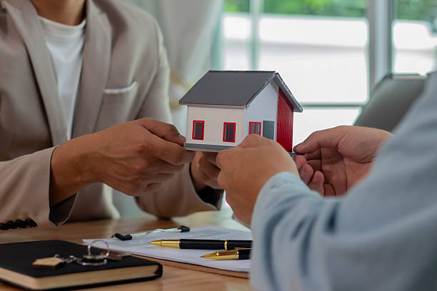 istock Middle-aged male real estate agent sitting in modern office, analyzing property documents and graphs, preparing sales agreement for residential investment, mortgage or loan transaction document for client. 2221427181