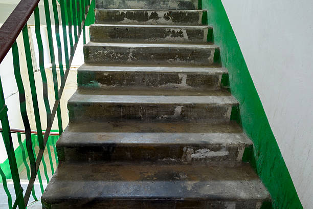 istock concrete staircase with steps with green railings in building, close up 2221428600