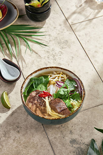 istock Pho bo soup with rare beef, bright lighting, overhead composition on stone countertop 2221431235
