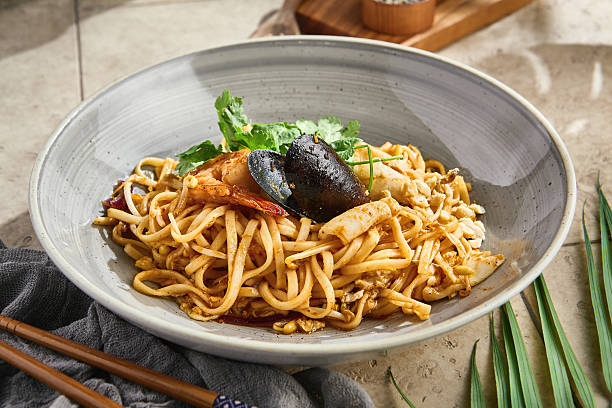 istock Wok-fried noodles with seafood, bright natural light, overhead restaurant composition 2221433591