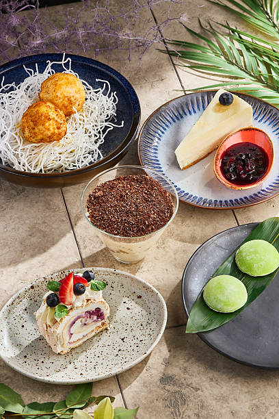 Meringue roulade, sesame mochi, cheesecake, tiramisu, fried ice cream, bright rustic overhead composition