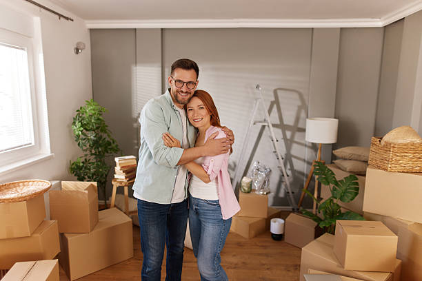 istock Happy couple embracing in new home with moving boxes 2221435473