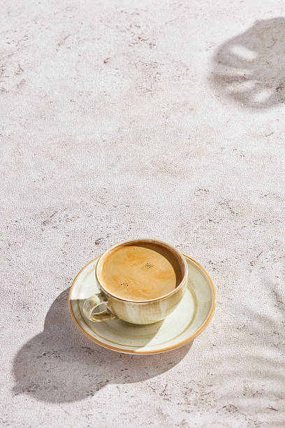 istock Coffee cup on ceramic saucer, bright sunlit rustic mood, minimal overhead composition 2221435811