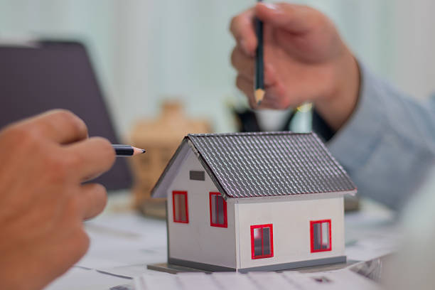 istock Architect and businessman discussing interior mansion plans using pencils and models at desk, including real estate purchase planning with leaders, marketing and engineering insights. 2221438764