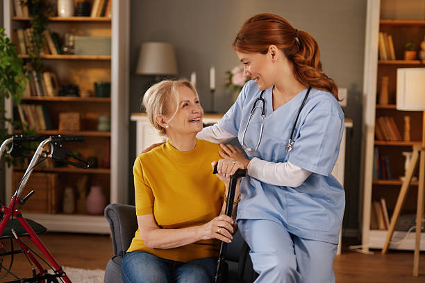 istock Nurse supporting elderly woman holding a walking stick at home 2221442933