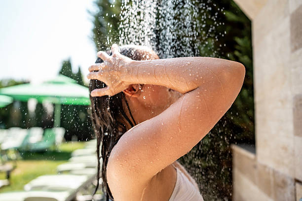 istock Woman Showering Outdoors Amidst Sunny Comfortable Resort Environment 2221448451