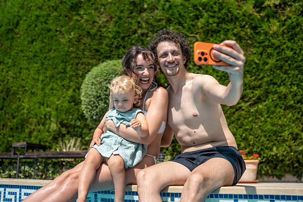 istock Family Taking a Poolside Selfie on a Sunny Summer Day 2221448479