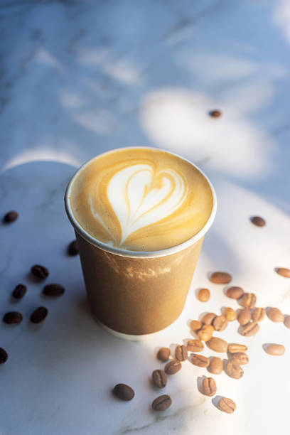 istock Hot latte coffee in take away paper cup on white marble table with roasted coffee beans. 2221452059