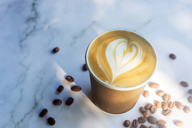 istock Hot latte coffee in take away paper cup on white marble table with roasted coffee beans. 2221452061