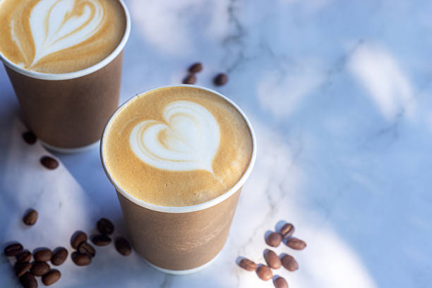istock Hot latte coffee in take away paper cup on white marble table with roasted coffee beans. 2221452062