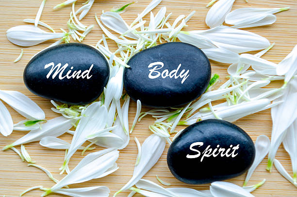istock Three stacked stones with mind and body text beside white petals 2221453288