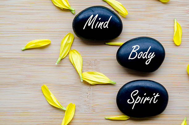 istock Three zen stones with words mind and body and scattered petals 2221453309