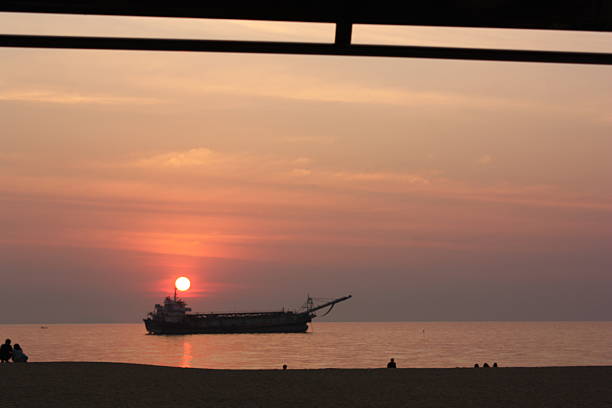 Beautiful orange sunset over the sea, a ship on the horizon