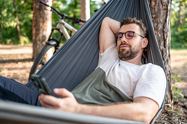 istock Man Relaxing in a Hammock Outdoors with a Bicycle Nearby 2221460499