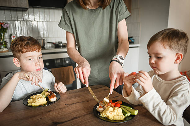 istock mother feeds her little sons 2221461916