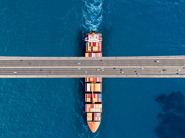 istock Aerial view of a cargo ship passing under bridge. Cargo Ship Beneath Bridge. 2221462867