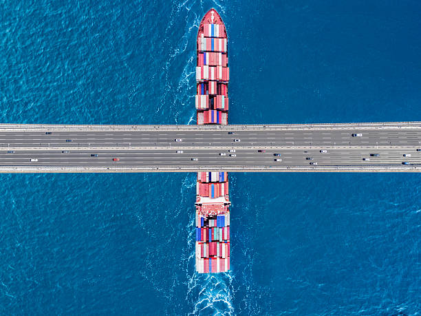 istock Aerial view of a cargo ship passing under bridge. Cargo Ship Beneath Bridge. 2221463217