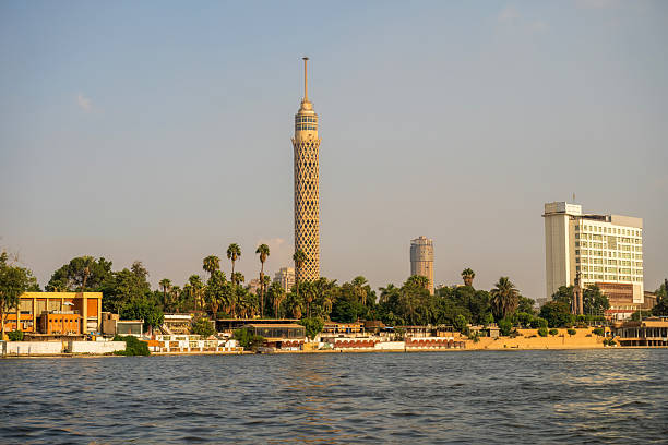istock Cairo skyline featuring the iconic Cairo Tower, lush palm trees, and Nile River waterfront under a clear sky 2221463796