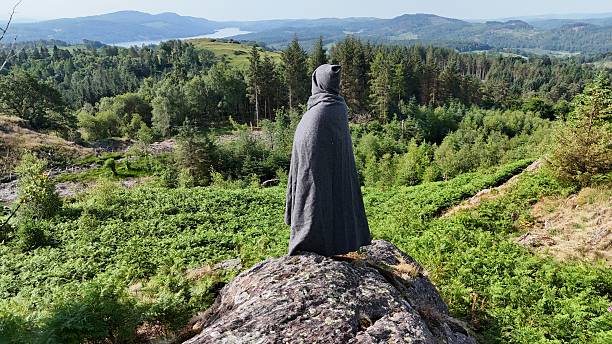 istock Cloaked Figure Overlooking Forested Hills 2221463982