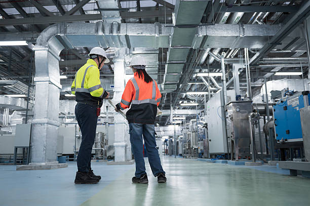 istock Asian Engineer Performing Pipe System Inspection in Modern Industrial Facility.  Industrial Engineers Collaborating in a Modern Factory. 2221465420