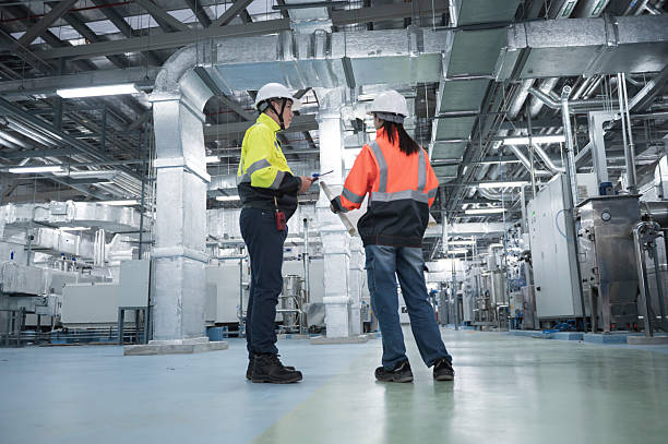 istock Asian Engineer Performing Pipe System Inspection in Modern Industrial Facility.  Industrial Engineers Collaborating in a Modern Factory. 2221465422