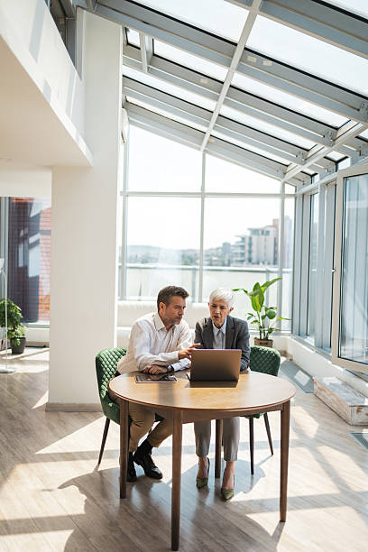 istock Business professionals collaborating in a modern office space with a laptop 2221467497